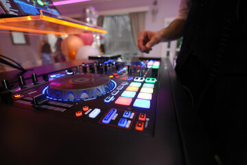 DJ table mixer closeup in the nightclub during the event party