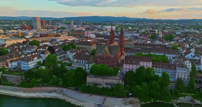 Aerial drone footage of the Basel old town along the Rhine river which contrast with modern skyscrapers in Switzerland. Shot with a forward and rotation motion. 