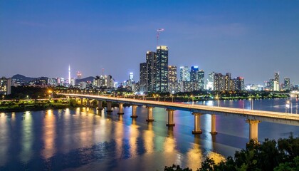 Obraz premium City skyline reflecting on the Han River in Seoul, South Korea, at night, showcasing the illuminated buildings and bridge in a tranquil urban scene.