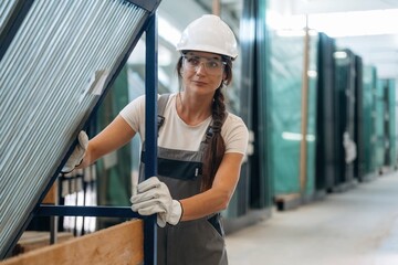 Moving the new batch of glass. Woman is in the window making factory