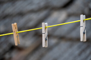 Wooden clothespins on yellow clothesline