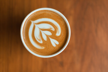 Close up cup of hot latte art coffee on wooden table