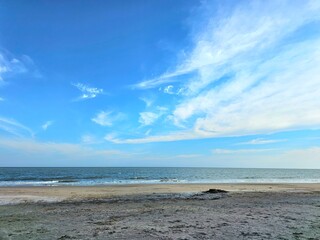 Peaceful tropical beach scene with golden sand, blue sea, and bright sky. Ideal for summer travel, holiday backgrounds, and relaxation concepts.