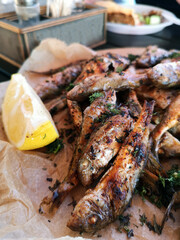 fried red mullet with a slice of lemon close-up in a summer cafe