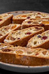 Italian Almond Biscotti biscuits in a rustic home made pottery bowl. Studded with almonds and cranberries, these twice-baked treats are aromatic and inviting. Ideal.