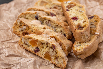 Italian Almond Biscotti biscuits in a rustic home made pottery bowl. Studded with almonds and cranberries, these twice-baked treats are aromatic and inviting. Ideal.
