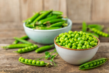 Fresh green pea pods with green peas on a wooden background. Sweet green peas. Green pea beans vegetables. Vegan. healthy vegetable. Copy space