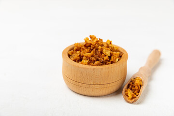 Crispy fried onions in a bowl on a wooden table. Roasted Onions. Seasoning for dishes. Spices. Salad dressing. Space for text. Copy space
