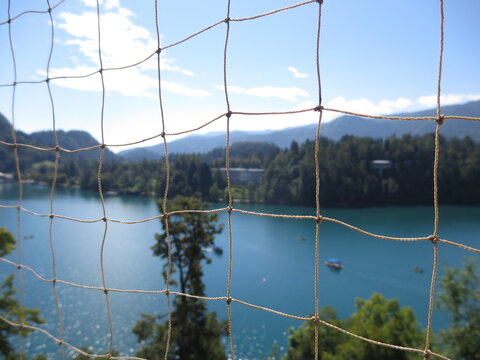 Bled, Slovenia – : Lake Bled scenic view through safety net from the church tower on Bled Island - Powered by Adobe