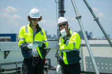Engineers inspecting rooftop telecommunications tower