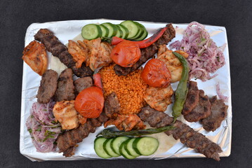 mixed grilled meat varieties on a foil-lined plate
