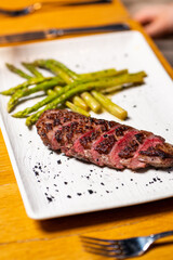 Grilled beef steak with asparagus on white plate
