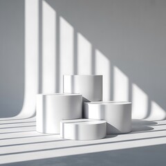 Minimalist white pedestals with dramatic light and shadow patterns