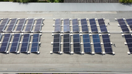 Aerial top view of multiple solar panels mounted on a flat roof of an industrial building for sustainable electricity production. Tilt mount system flat roof © Dmitry Koshelev