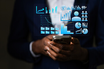 African Business person holds phone displaying glowing data visualizations, charts, and icons, analytics and technology.