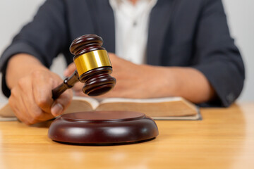 Close-up of a gavel with a judge in the background, symbolizing law, legal proceedings, justice, and courtroom authority