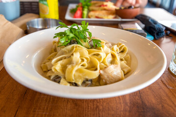 Delicious fettuccine pasta served with creamy sauce and chicken in a casual dining restaurant setting