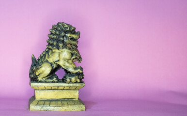 Chinese Guardian Lion Statue on Pink Background ,Symbol of Protection and Feng Shui