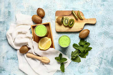 Glasses of fresh kiwi smoothie with mint and lemon on light blue background