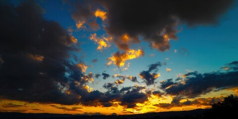 The sunset bathes the sky in fiery oranges and deep blues, creating a breathtaking landscape.