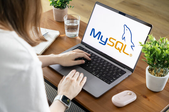 Poznan, Poland - August 23, 2025: MySQL application prominently displayed on laptop screen, person actively typing, representing modern database management solutions