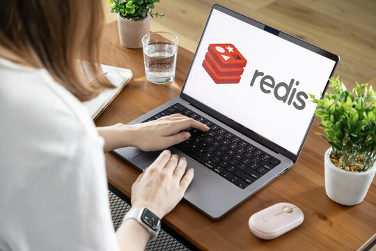 Poznan, Poland - August 23, 2025: Redis application logo displayed on laptop screen as person types, signifying database technology and software development