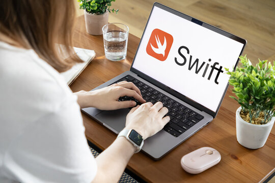 Poznan, Poland - August 23, 2025: Swift application logo prominently visible on a laptop screen with a person typing, signifying modern programming and technology