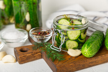 Freshly-salted homemade cucumbers in a jar on a wooden background. pickled cucumbers with dill,garlic and pepper.canned cucumbers.cucumbers and dill.Recipe of homemade preservations.fermented veggies.