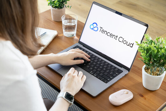 Poznan, Poland - August 23, 2025: Tencent Cloud application shown on laptop, a person working, representing modern digital infrastructure and cloud computing services