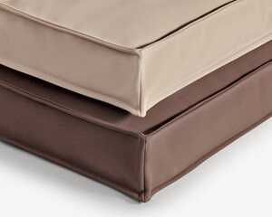 Two square cushions showing stitching and neutral colors