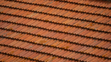 Closeup of old red clay roof tiles showing texture, weathering and natural details