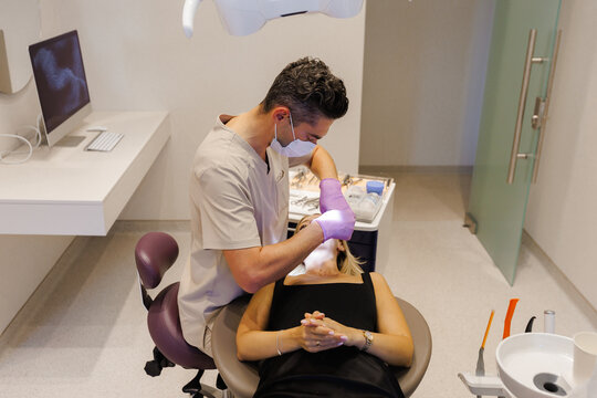 A Professional Dentist Carrying Out a Procedure on a Patient in a Modern, Welcoming Clinic