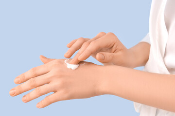 Fototapeta premium Woman applying natural cream on color background, closeup