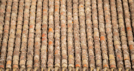 Closeup of traditional clay barrel roof tiles showing age, texture, and natural wear