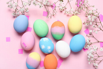 Composition with painted Easter eggs, gypsophila flowers and confetti on pink background