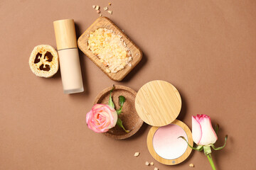 Makeup products with sea salt and roses on brown background. Eco style concept