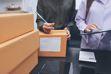 Portrait of Starting small businesses SME owners, two Asian woman check online orders Selling products working with boxs freelance work at home office, sme business online small medium enterprise
