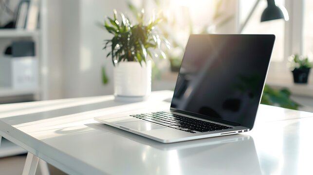 Laptop on a white desk in a bright and modern office space, creating a clean and productive work environment with natural light