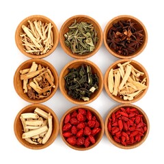 Nine small wooden bowls hold various dried herbs and teas, showcasing a collection of natural remedies against a plain white background.