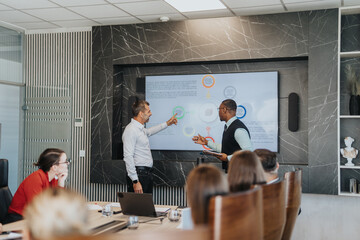 Fototapeta premium A diverse group of business people engaging in a brainstorming session. They are analyzing and discussing solutions on a digital board in a contemporary office setting.