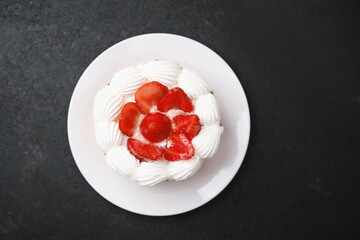Strawberry shortcake with whipped cream topping on white plate dessert concept for birthday celebration or sweet food advertising