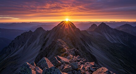 Fototapeta premium Majestic Mountain Sunrise: Golden Rays Bursting Over Jagged Peaks and Rocky Terrain
