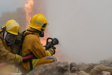 Firefighters are working together to put out the fire with water.
