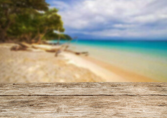 Fototapeta premium Wooden table top on the beach or sea.Party on the beach sunshine time concept.For montage product display or design key visual layout.View of copy space.