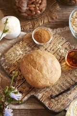 Ball of raw dough made of whey protein powder, ground oat flakes, maple syrup and peanut butter - preparation of homemade bars