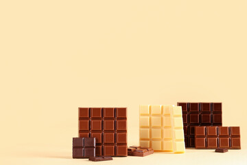 Different sweet chocolate bars on beige background