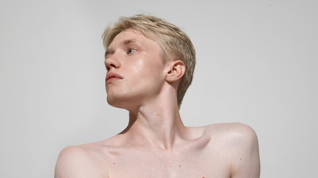 Male beauty portrait with glowing skin and sculpted jawline. Concept of selfcare, men grooming, wellness, skincare industry, personal expression and lifestyle branding.