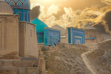View on a walls decorated geometric pattern with ceramic tiles against a cloudy dusk sky. Earthen...