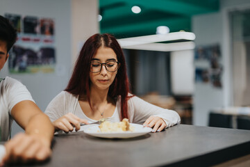 A group of high school students enjoying a meal together in a modern school cafeteria environment, engaging in conversation and community bonding.