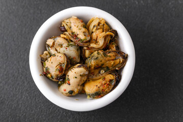 Grilled mussels with herbs in white bowl for rustic seafood or mediterranean cuisine concept